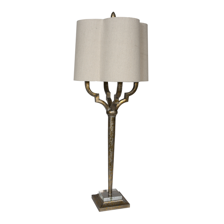 Antique gold table lamp with sculpted metal base and scalloped beige fabric shade on white background