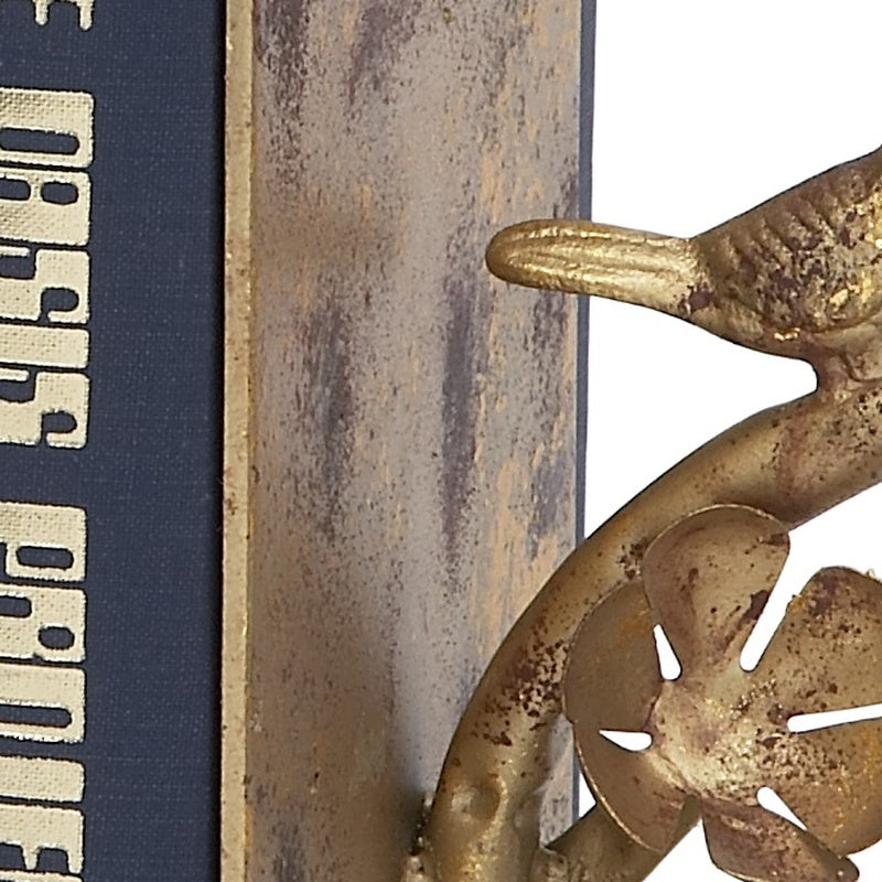 Close-up antique gold bird bookend detail with arched branch on metal base.