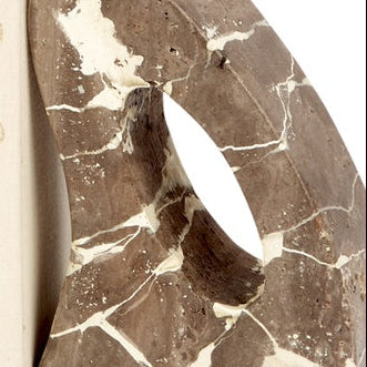 Beige travertine bookend detail with oval cutout and white veining
