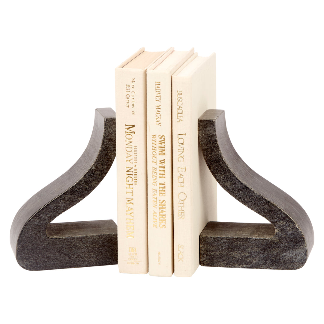 Black marble bookends with ornate curved cutouts, holding stacked cream books