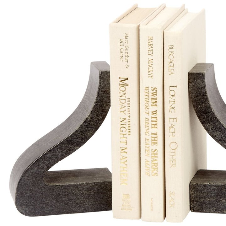 Black marble bookends with curved supports, holding cream hardcover books