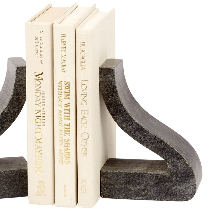 Black marble bookends with speckled texture and curved arms, holding cream books