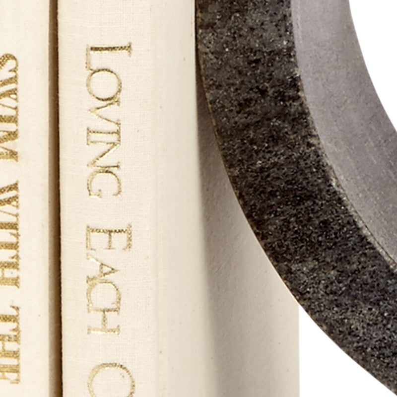 Close-up of cream book spine and black marble curved edge of bookend