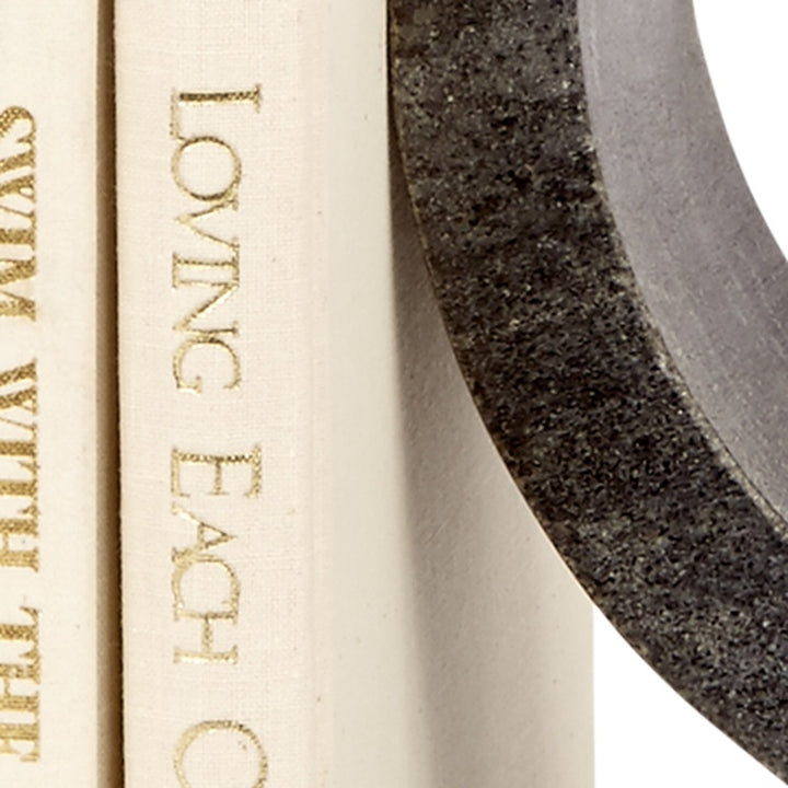 Close-up of cream book spine and black marble curved edge of bookend