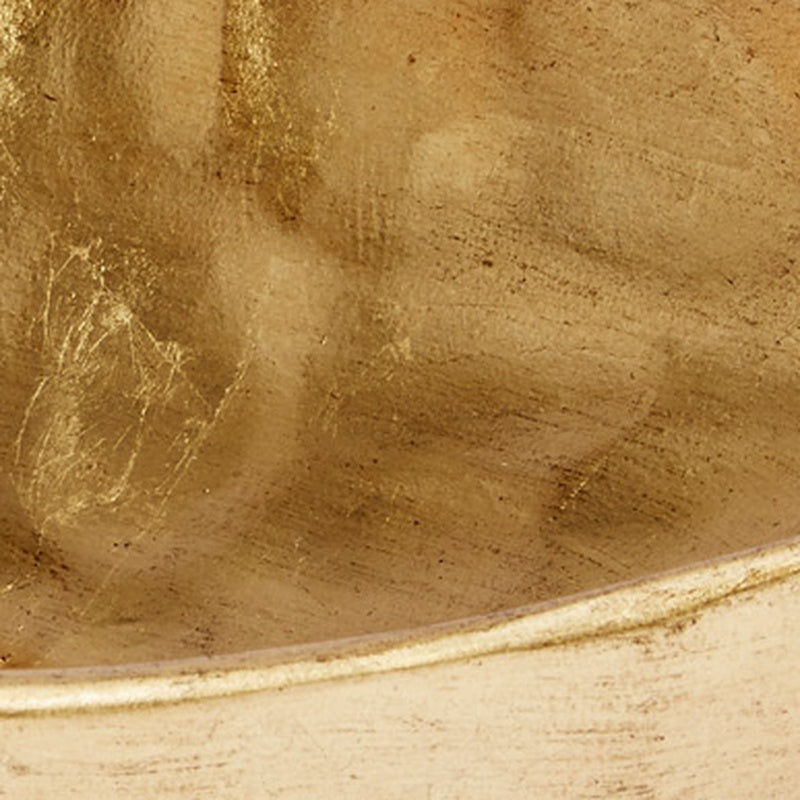 Gold decorative bowl interior close-up with hammered leaf-like pattern and shine