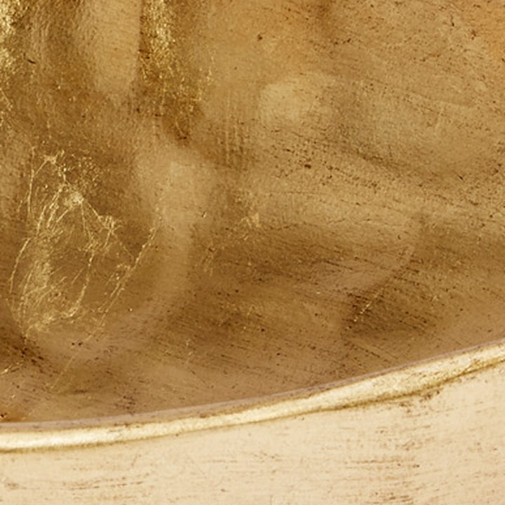 Gold decorative bowl interior close-up with hammered leaf-like pattern and shine