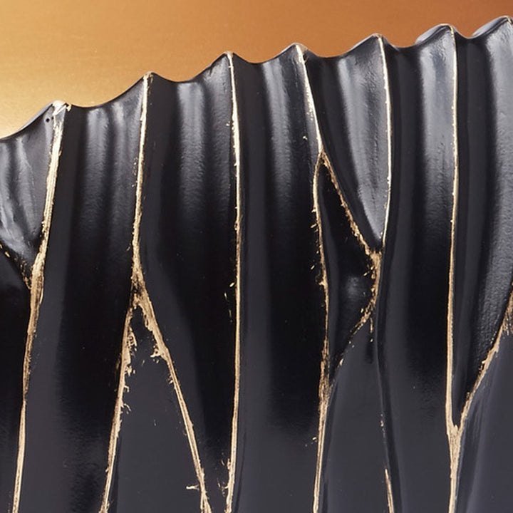 Decorative black bowl with gold accent streaks on vertical fluted sides
