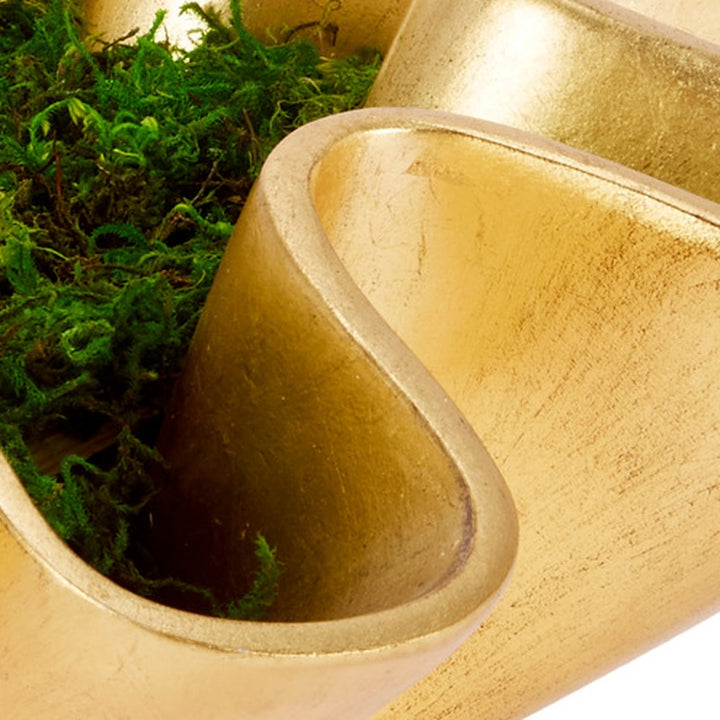 Gold leaf bowl opening with smooth gold interior and green moss on the edges