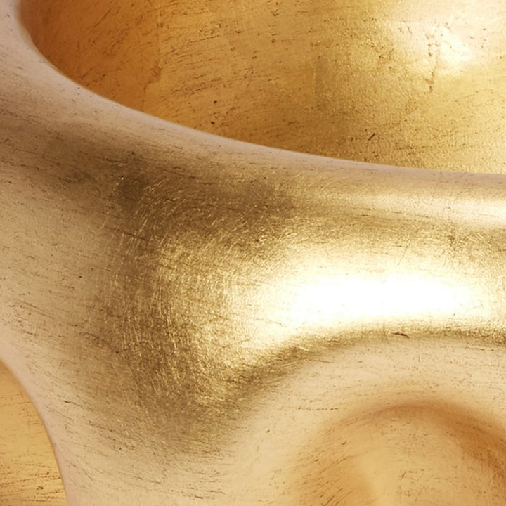 Gold leaf decorative bowl with smooth curved rim, close-up metallic texture