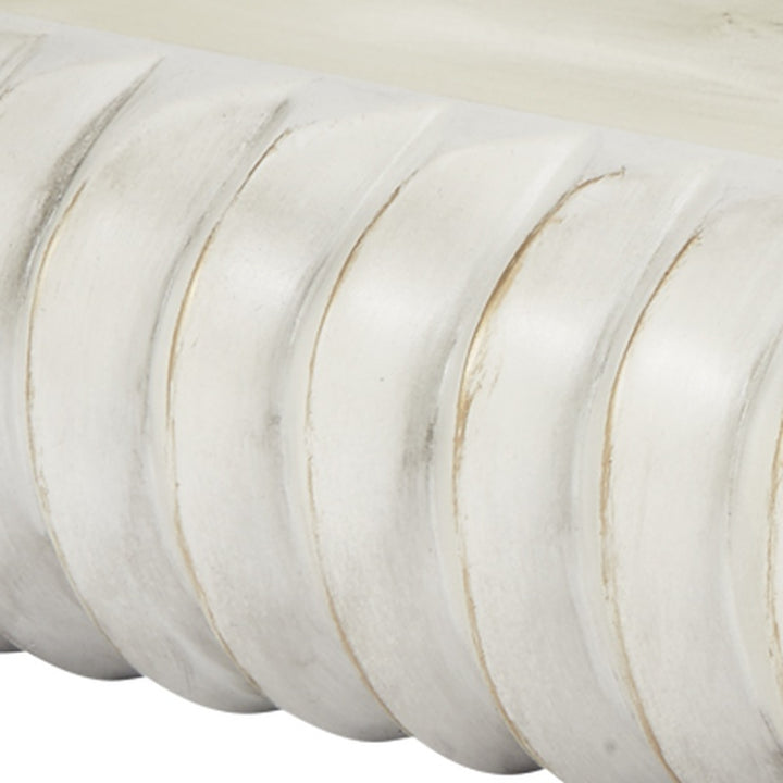 Cream oval bowl with carved ridges and thin gold accents, close-up texture