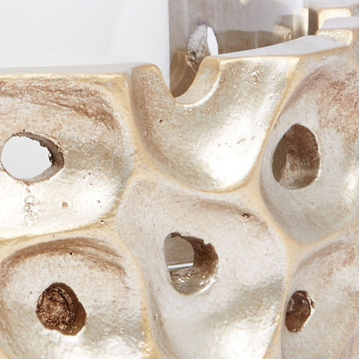 Champagne gold candle holder close-up with multiple wavy cutout openings