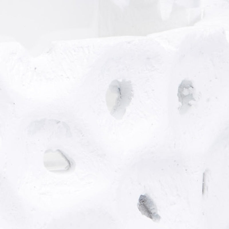 White gesso candleholder detail with irregular cutout holes on side