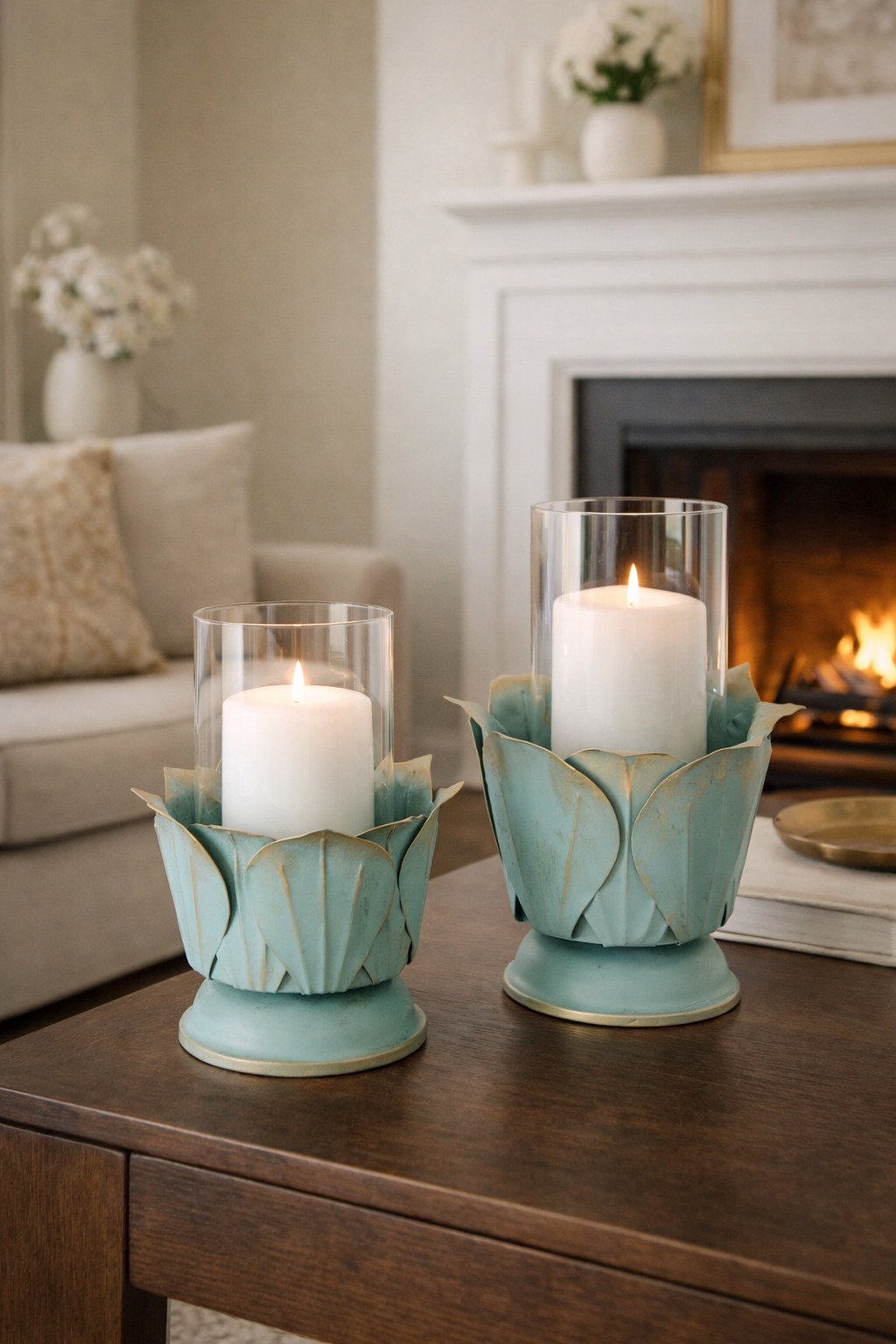Two candle holders with candles on a wooden table in a living room setting.