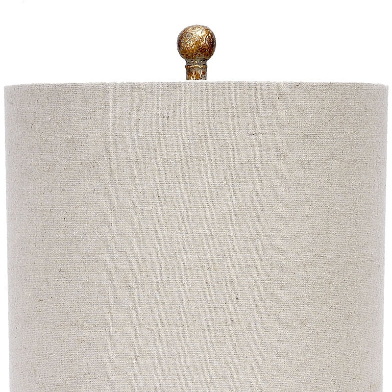 Table lamp with beige linen drum shade and aged gold lucite base