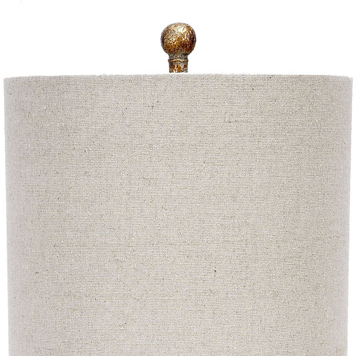 Table lamp with beige linen drum shade and aged gold lucite base