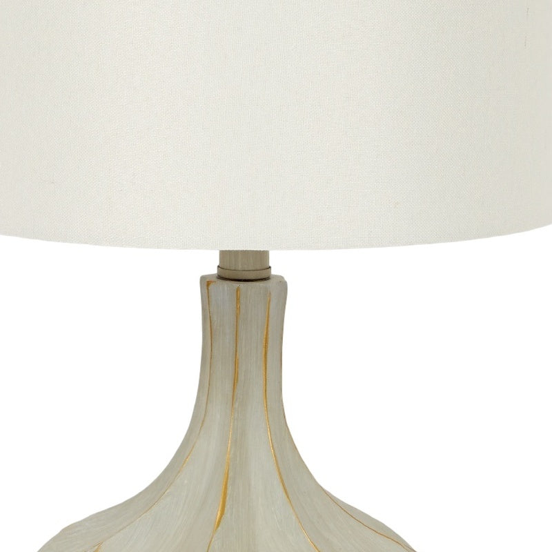 Table lamp with white fabric shade and light gray cement base with gold lines