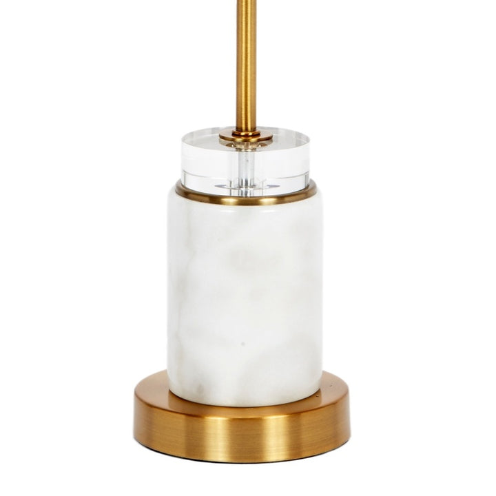 Marble-style base with clear sleeve and gold center post, under white linen shade