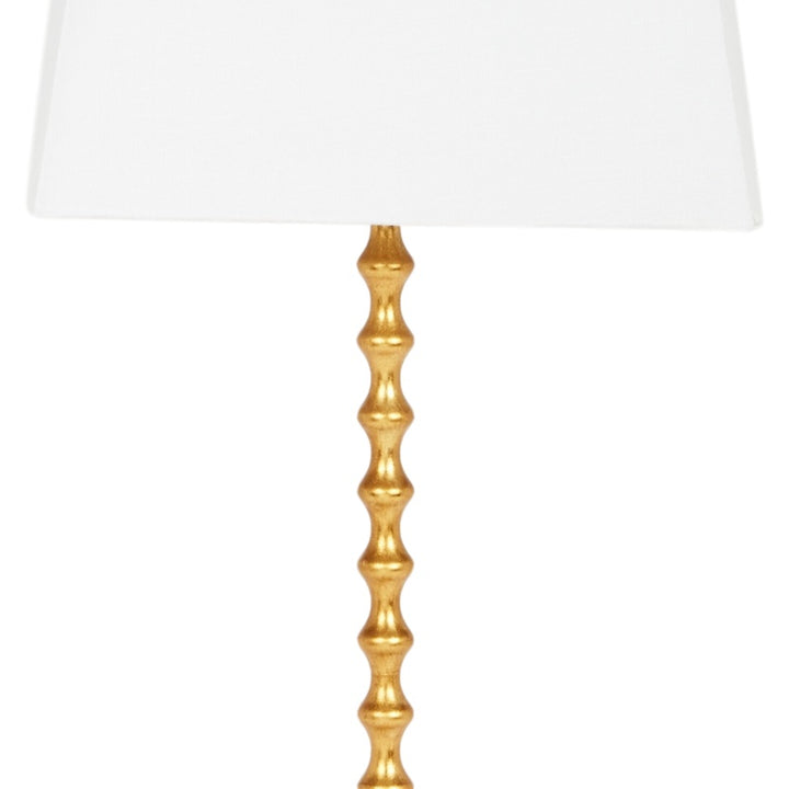 Gold fluted column base for a table lamp, paired with a white shade