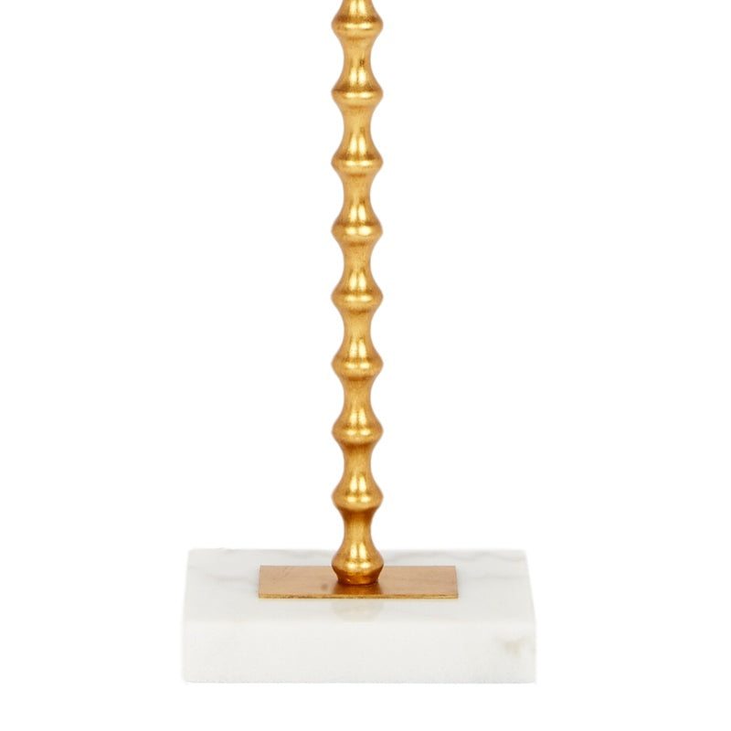 Gold ball finial and fluted column base of a table lamp with white shade