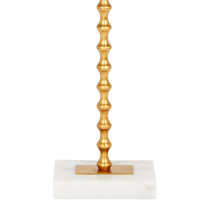 Gold ball finial and fluted column base of a table lamp with white shade