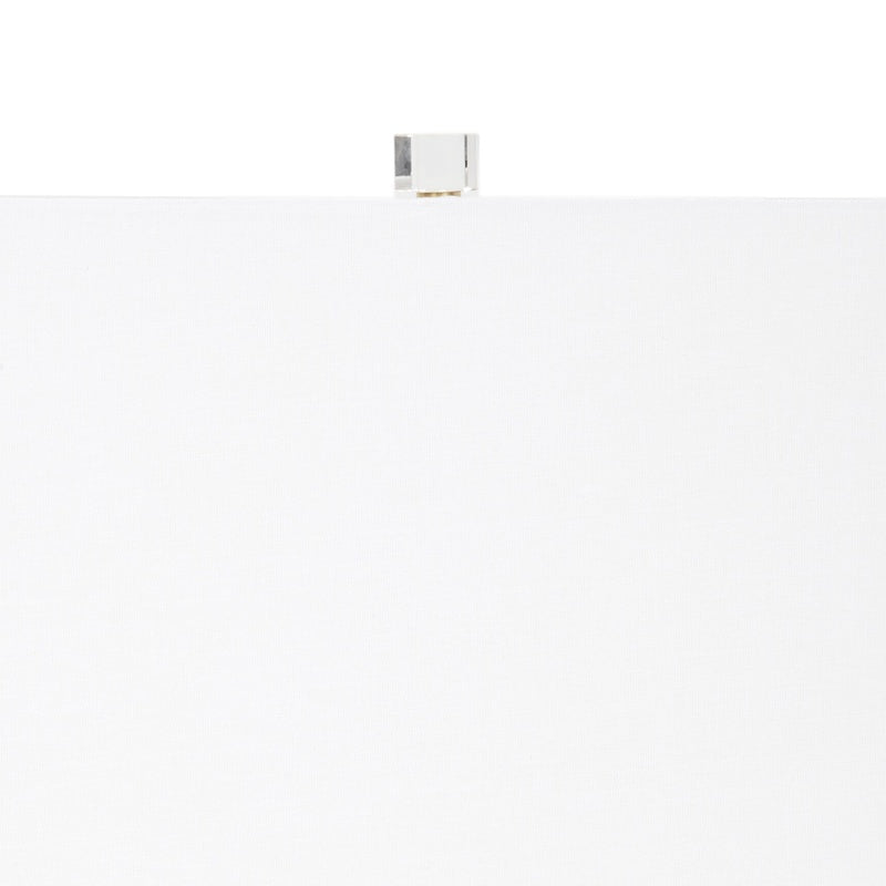 Table lamp top with white shade, brass finial, and clear center pole
