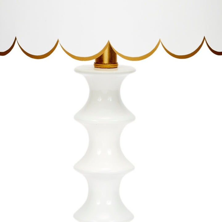 White ceramic table lamp base with gold finial and scalloped shade