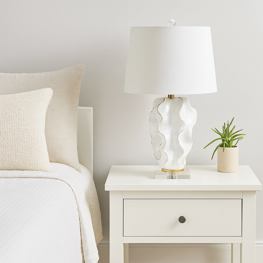 Hannah white ceramic lamp featuring luxurious gold accents and a crisp white linen shade, adding refined elegance to any room.