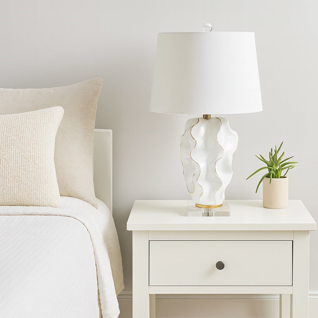 Hannah white ceramic lamp featuring luxurious gold accents and a crisp white linen shade, adding refined elegance to any room.