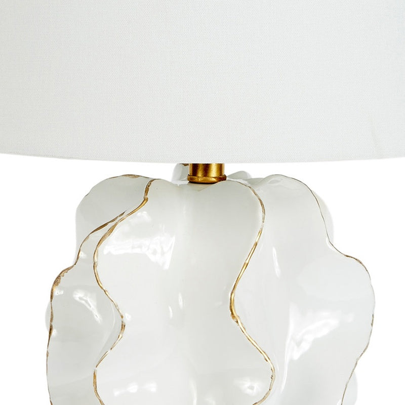 White ceramic lamp base with flowing gold accents under white linen shade