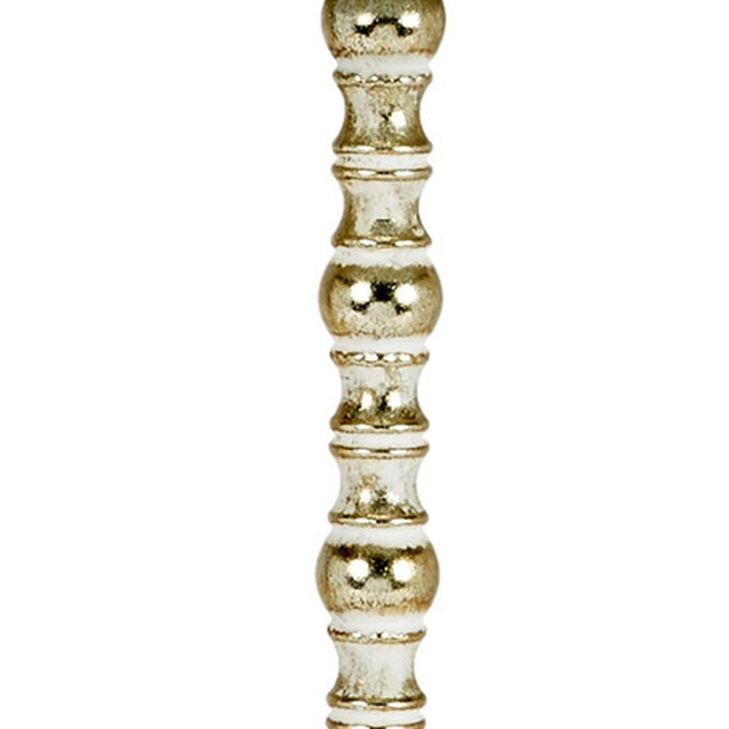 Close-up of ornate turned gold lamp stem with bead-like detailing