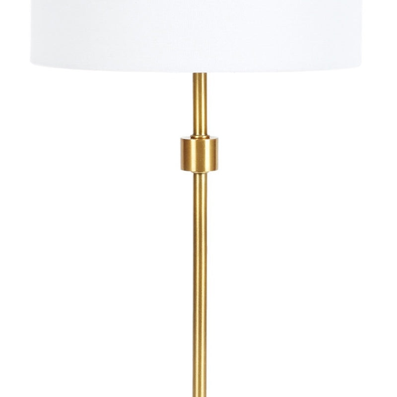 Table lamp with white fabric drum shade and tall brass column stem