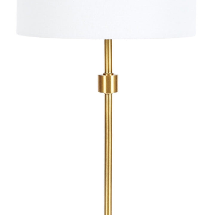 Table lamp with white fabric drum shade and tall brass column stem