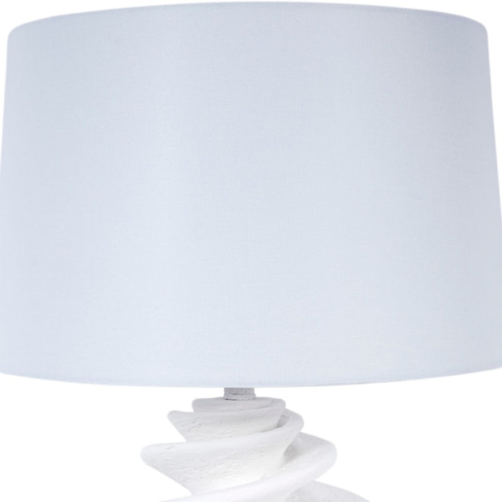 White shell-style table lamp with linen drum shade and white gesso spiral base