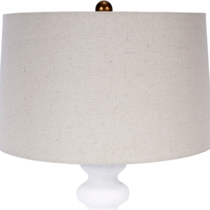 Table lamp with white fabric drum shade and white gesso base, close-up