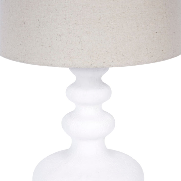 Table lamp with white gesso pedestal base and white fabric drum shade edge