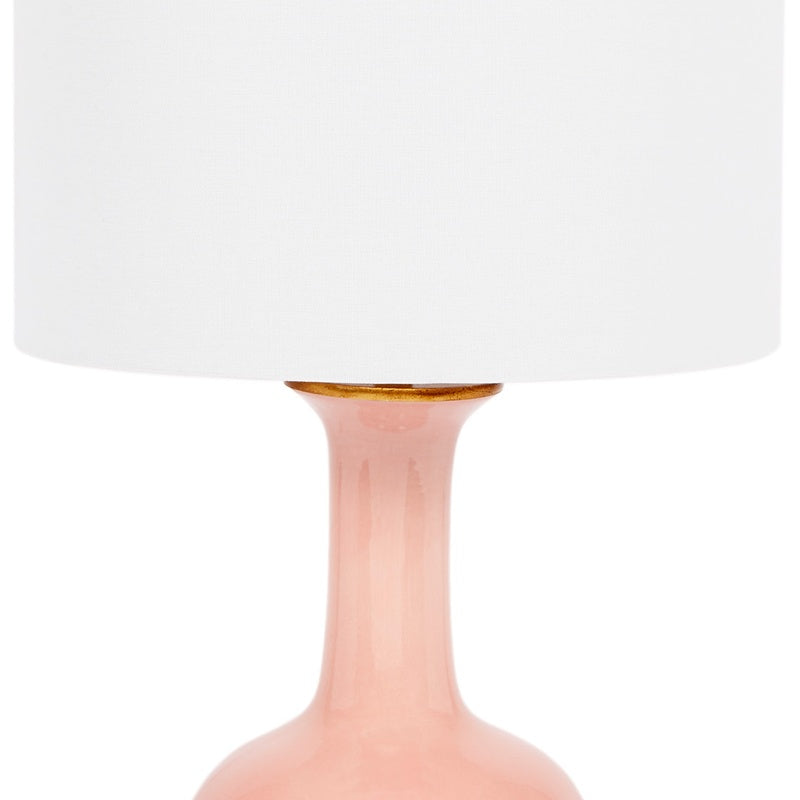 Blush ceramic table lamp with white linen shade, gold collar visible