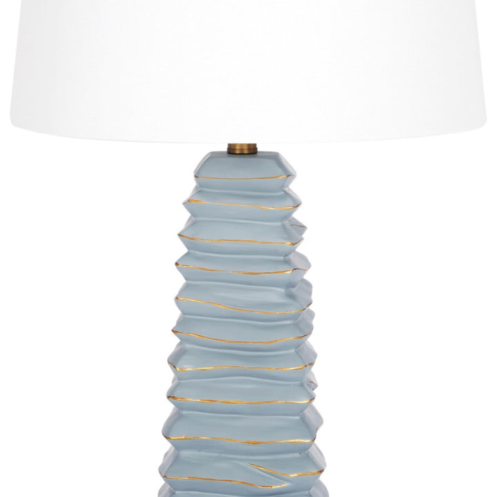 Table lamp with large white shade over layered soft teal ceramic base