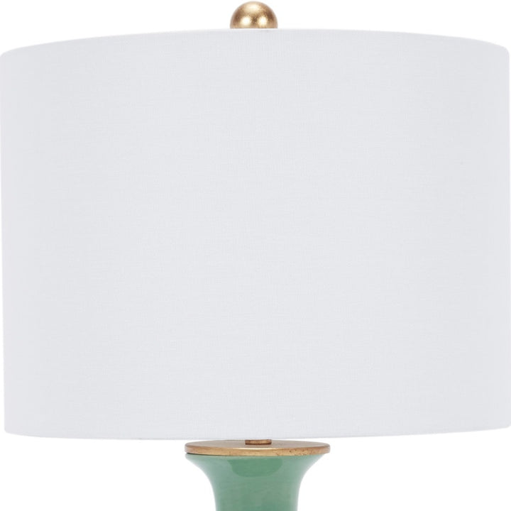 Green ceramic table lamp with white linen shade and brass finial