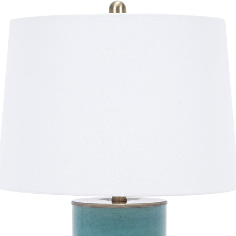 Blue ceramic table lamp with white linen shade and brass hardware