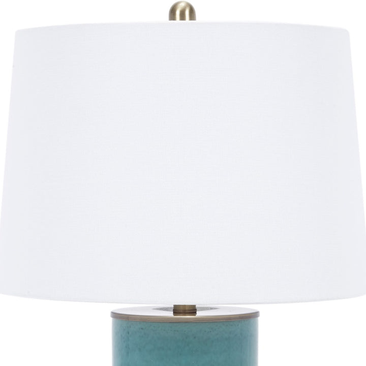 Blue ceramic table lamp with white linen shade and brass hardware