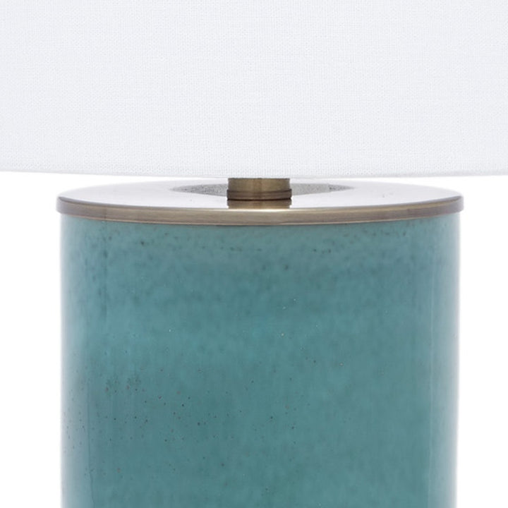Blue ceramic lamp top with white linen shade and brass finial