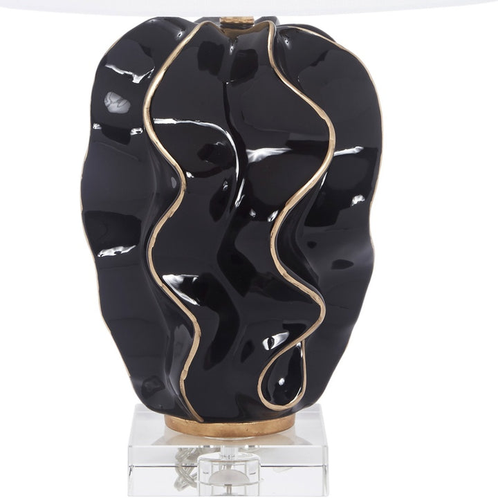 Wave table lamp with white shade, glossy black ceramic base, gold accents on stand