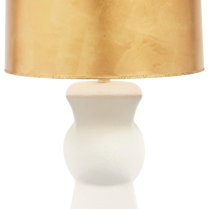 Gold drum lamp shade over white gesso pedestal with small gold connector