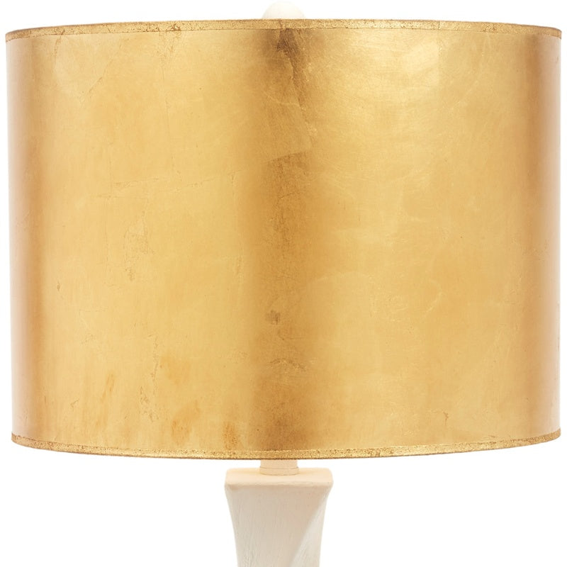 Table lamp with gold drum shade and off-white sculpted base
