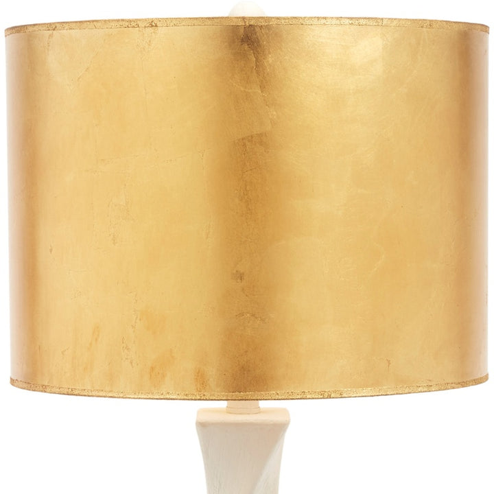Table lamp with gold drum shade and off-white sculpted base