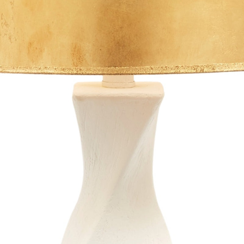 Table lamp base detail under gold-trimmed drum shade