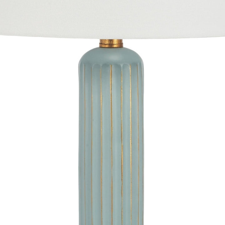 Teal table lamp base with vertical gold lines and brass top cap under white shade