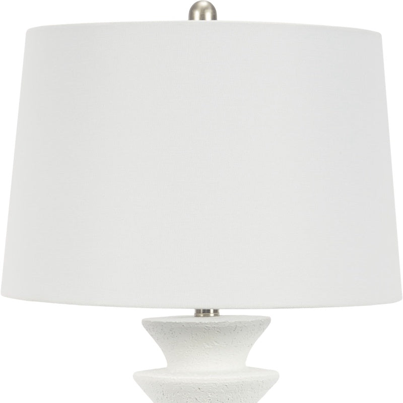 White resin table lamp with white fabric drum shade and stepped pedestal base