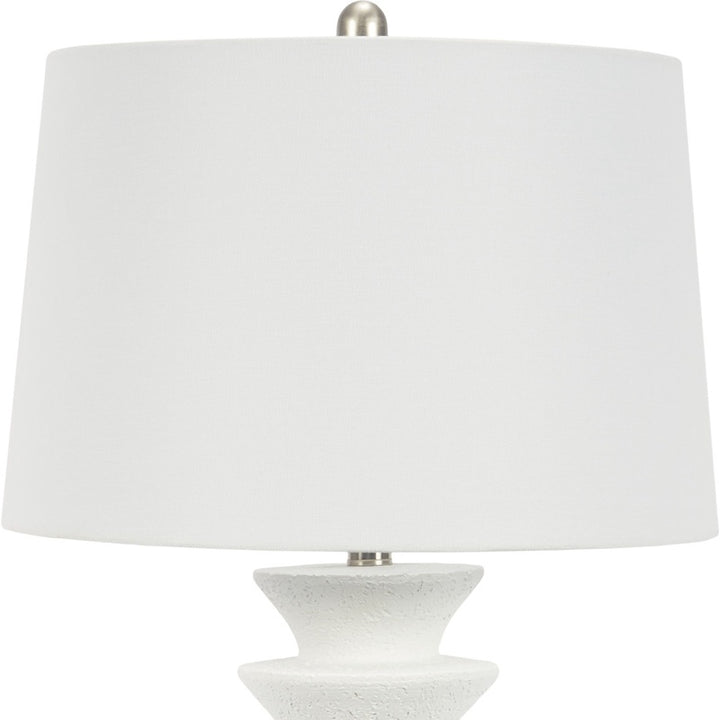 White resin table lamp with white fabric drum shade and stepped pedestal base