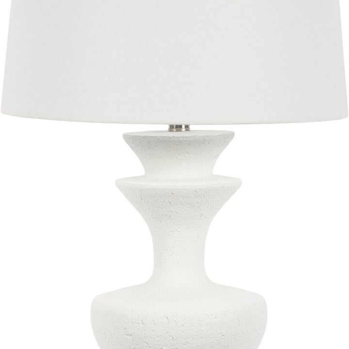 White resin table lamp, close view of white fabric shade and speckled pedestal